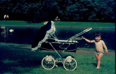 [Ivo Herzog criança segura alça de carrinho de bebê em parque]